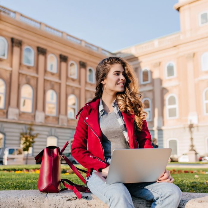 interested-dark-haired-girl-wears-casual-attire-chilling-park-near-university-using-laptop